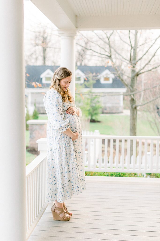 Maternity photo of a mother holding her baby bump at the Historic Ambassador House near Indianapolis, Indiana by photographer Katelyn Ng.