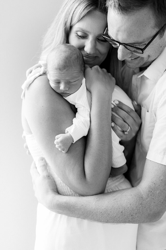 A black and white photo of parents holding their newborn son in a portrait by Katelyn Ng, Indianapolis photographer.