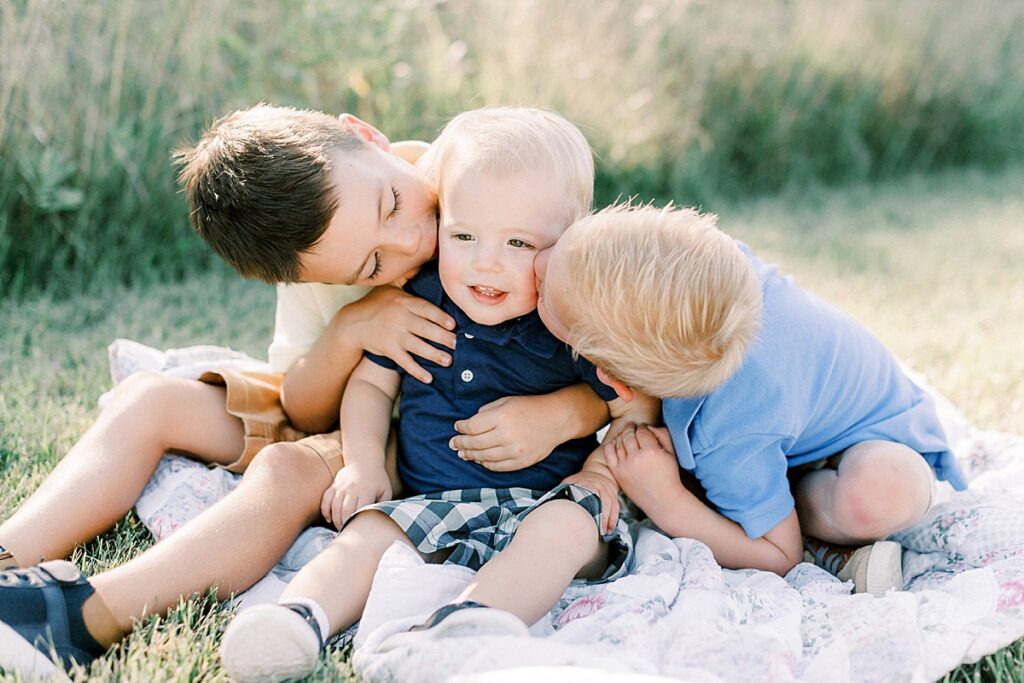 Three young boys sit on a blanket together in a family photo by greenwood Indiana family  photographer Katelyn Ng.