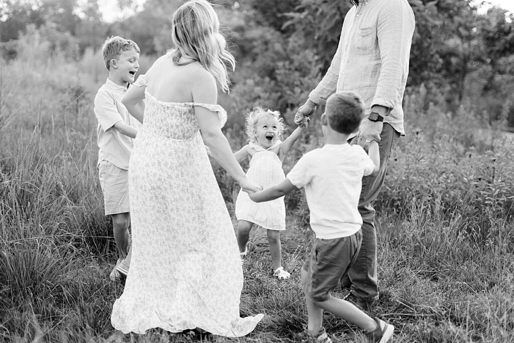 Family plays ring around the rosie in their family photos in Carmel, Indiana.