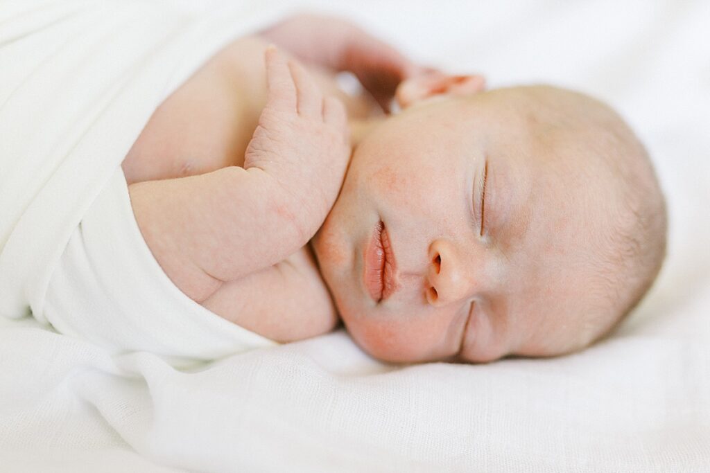 Newborn baby girl sleeps on a white blanket in a photo by Carmel Newborn Photographer Katelyn Ng