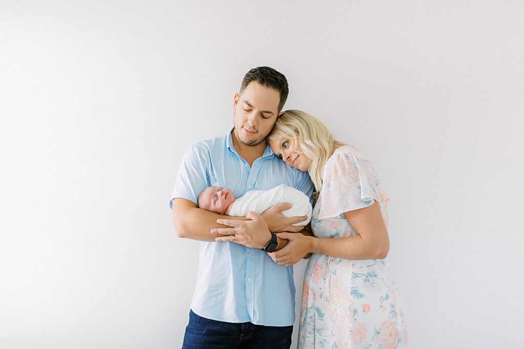 Newborn held by her mother and father in their home by Carmel Indiana Newborn Photographer Katelyn Ng Photography