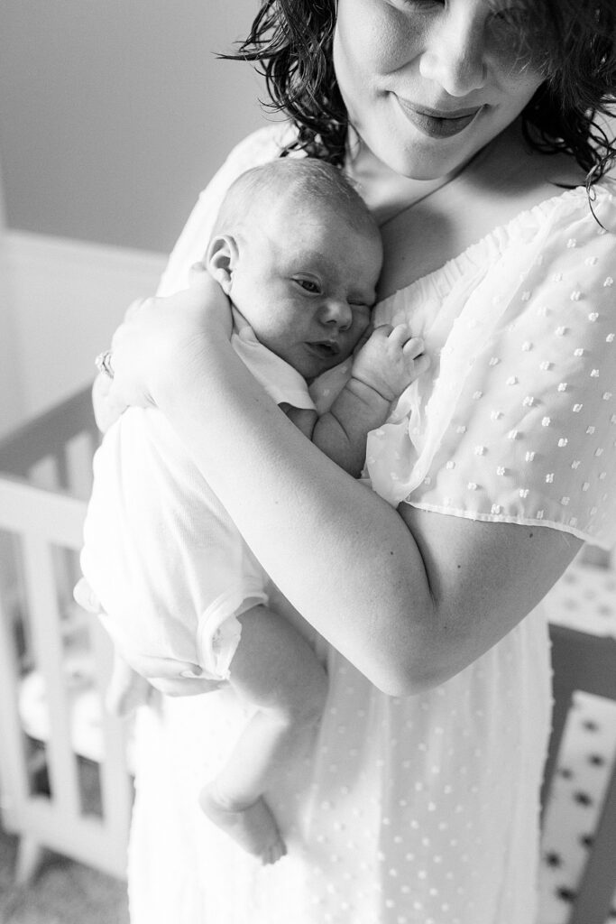 A black and white photo of a mother holding her newborn son by Katelyn Ng Photography.