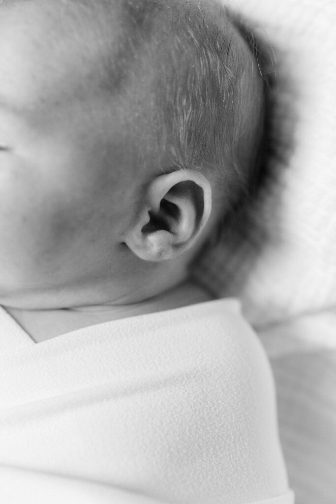 A black and white detail photo of a newborn's ear by Katelyn Ng Photography. 