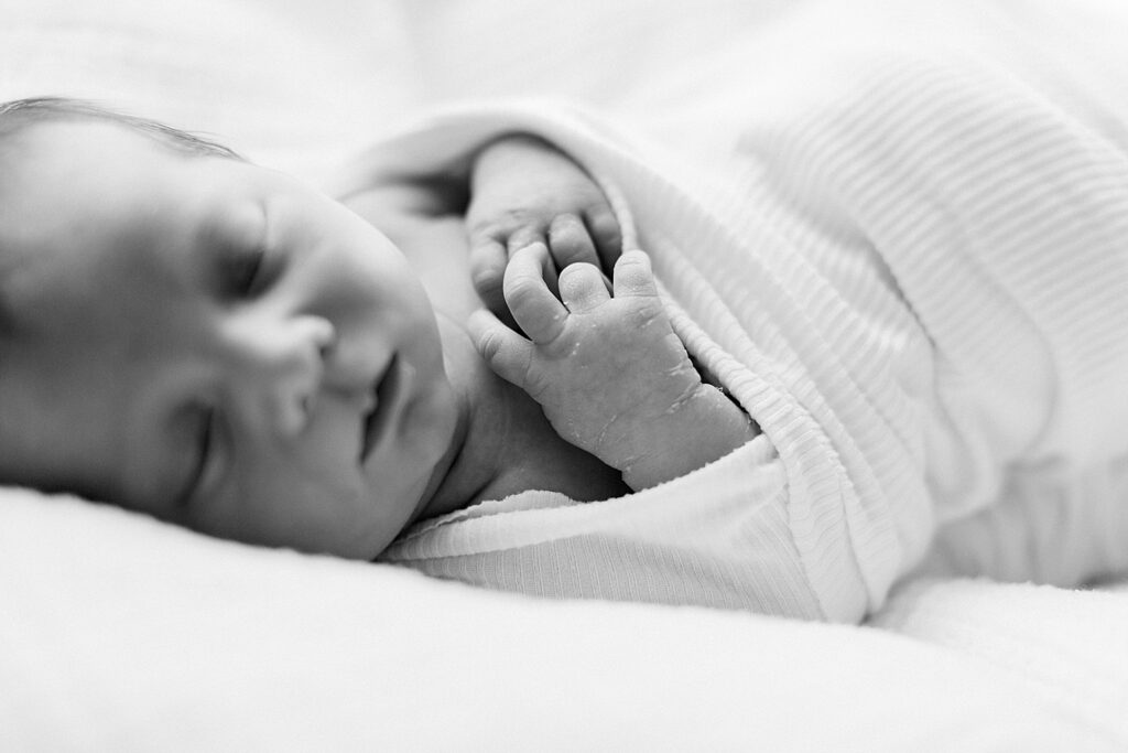 a black and white photo of a newborn boy laying on a white blanket Katelyn Ng, a Newborn photographer based in Indianapolis.
