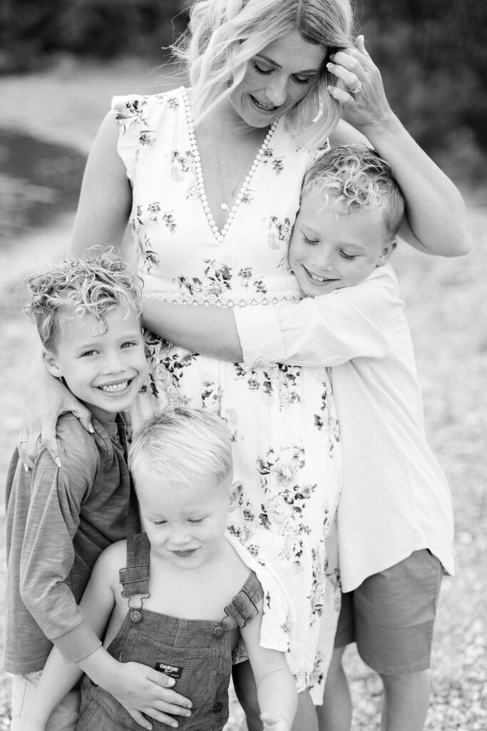 A mother and her sons snuggle together in a black and white family photo taken in Bloomington, Indiana by Katelyn Ng Photography.