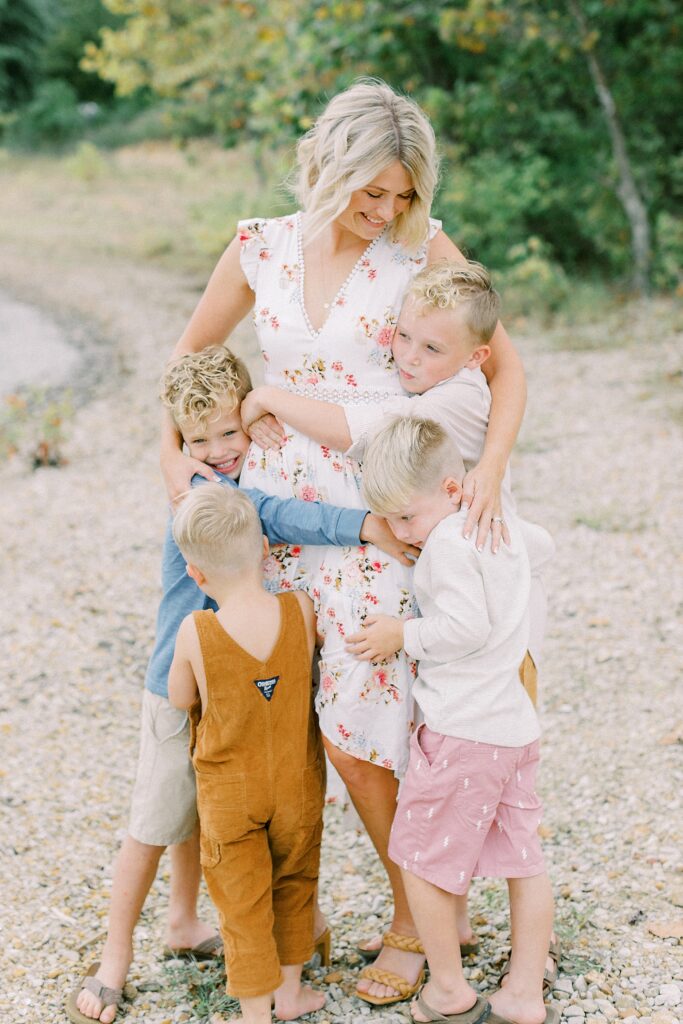 A mother smiles down at her four blonde sons during a family photo session in Bloomington, Indiana.