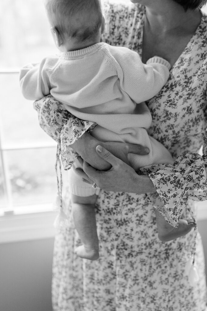 An emotive black and white photo of a mother tenderly holding her baby boy in her arms.