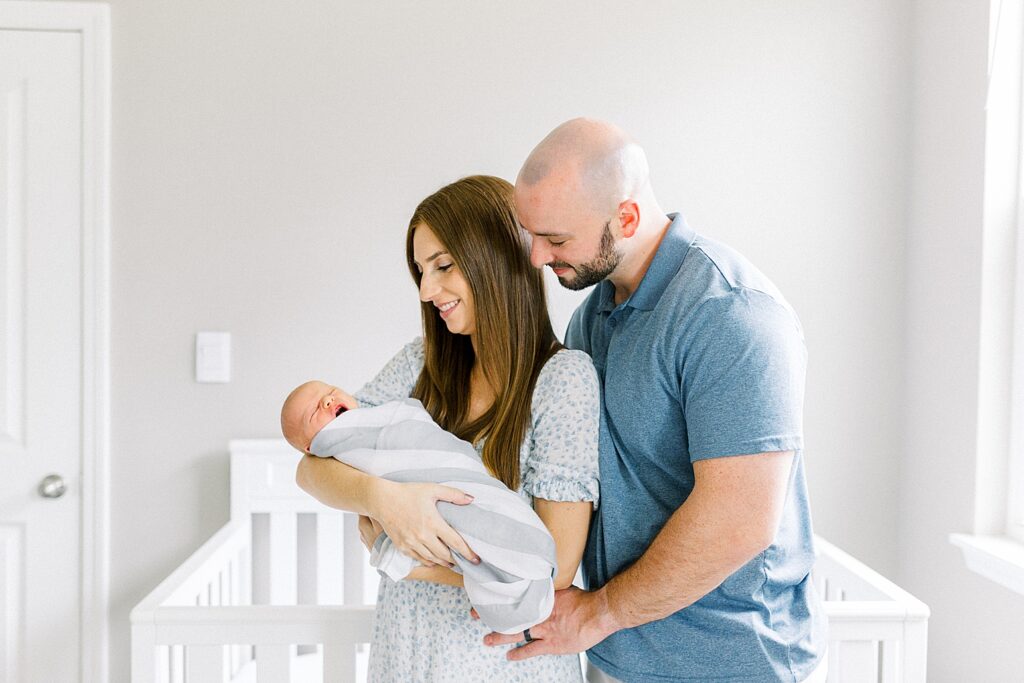 A mother and father hold their newborn son in their Indianapolis home during their in-home lifestyle newborn photos with Katelyn Ng Photography.
