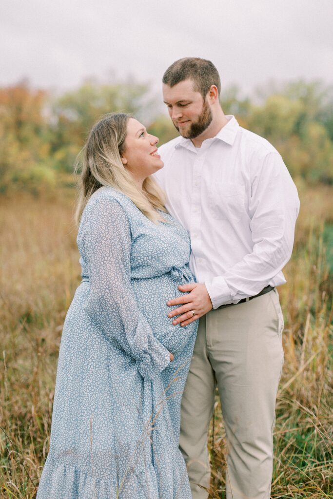 A woman poses with her husband during maternity photos with Carmel, Indiana Photographer Katelyn Ng Photography