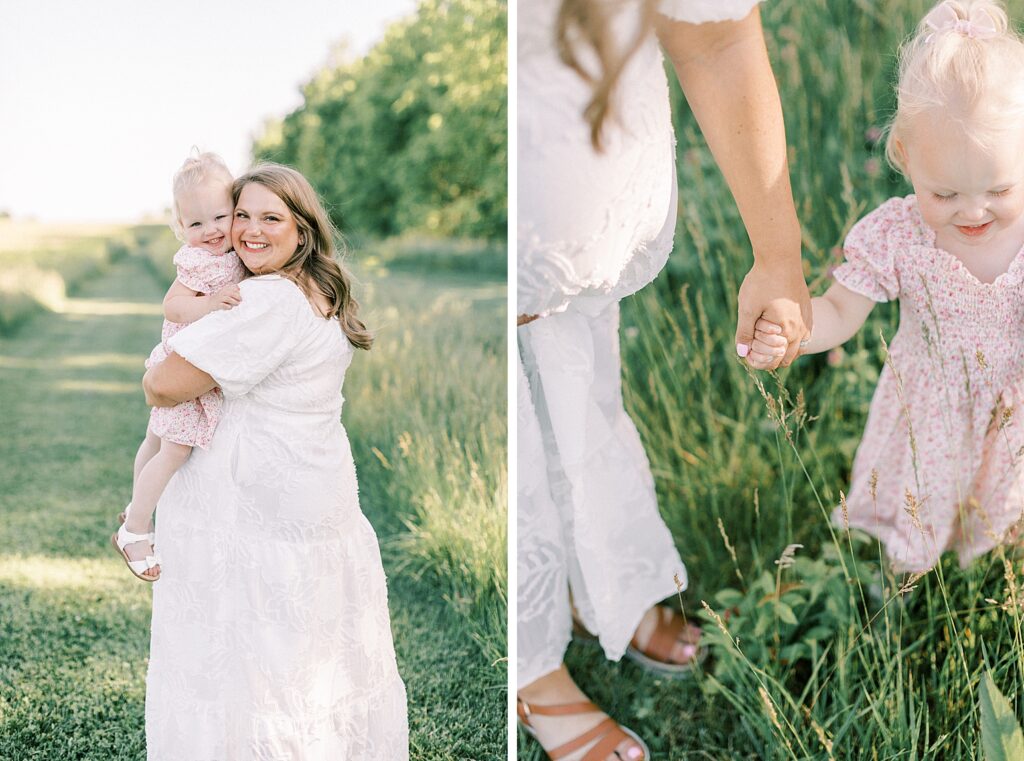 Woman holds her toddler daughter and snuggles close, tenderly holding her hand as they walk in an Indianapolis field during their photos with Indianapolis family photographer Katelyn Ng.