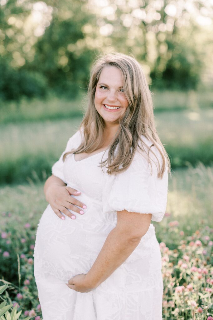 A maternity portrait of a pregnant woman standing in an Indianapolis field in a portrait by Katelyn Ng Photography.