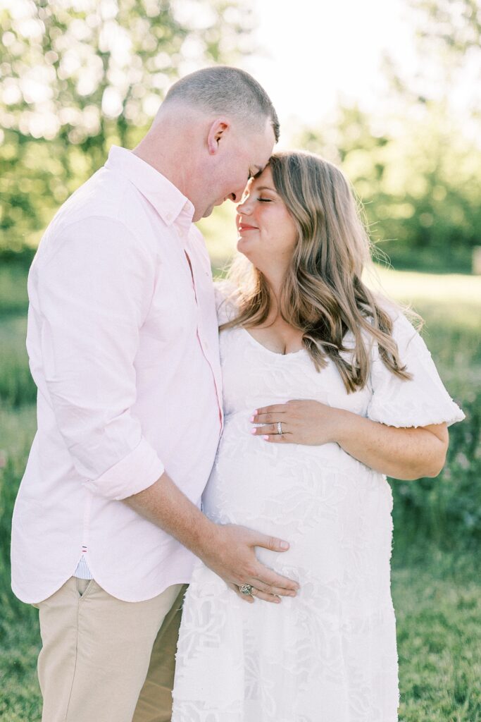 A man and woman pose together in the sunset glow during their family photos by Indianapolis photographer Katelyn Ng Photography.