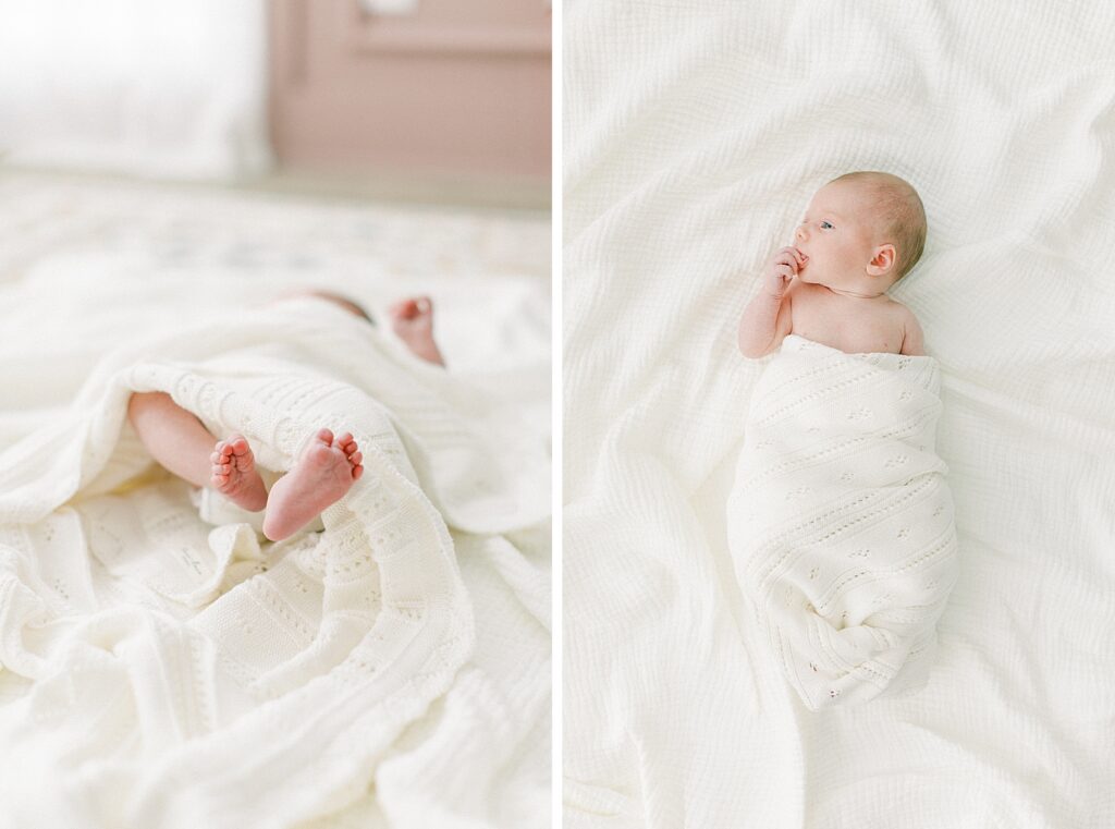 A white blanket wraps around a newborn girl who holds her hand to her mouth and stares up to the left hand corner of the image during her hewborn photos in Indianapolis.