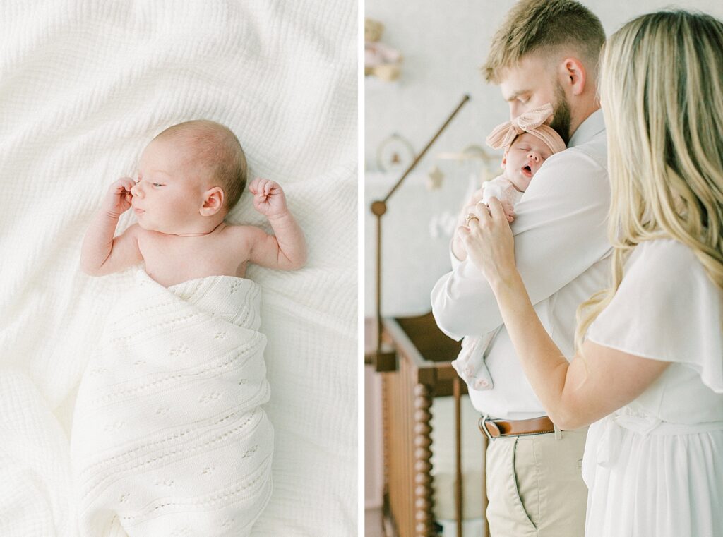 A father wearing a white shirt holds his sleeping newborn daughter as her mother looks on and holds the tiny newborn's hand.